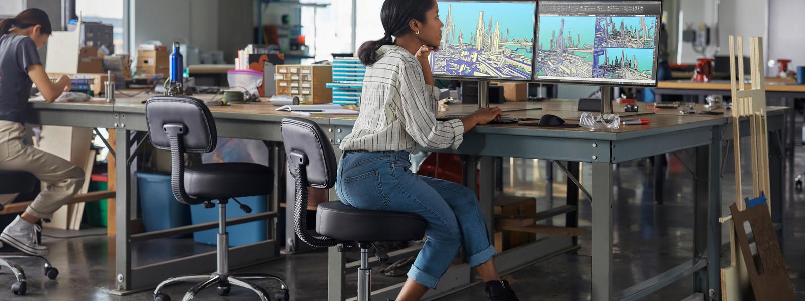 Woman at desk with multiple screens