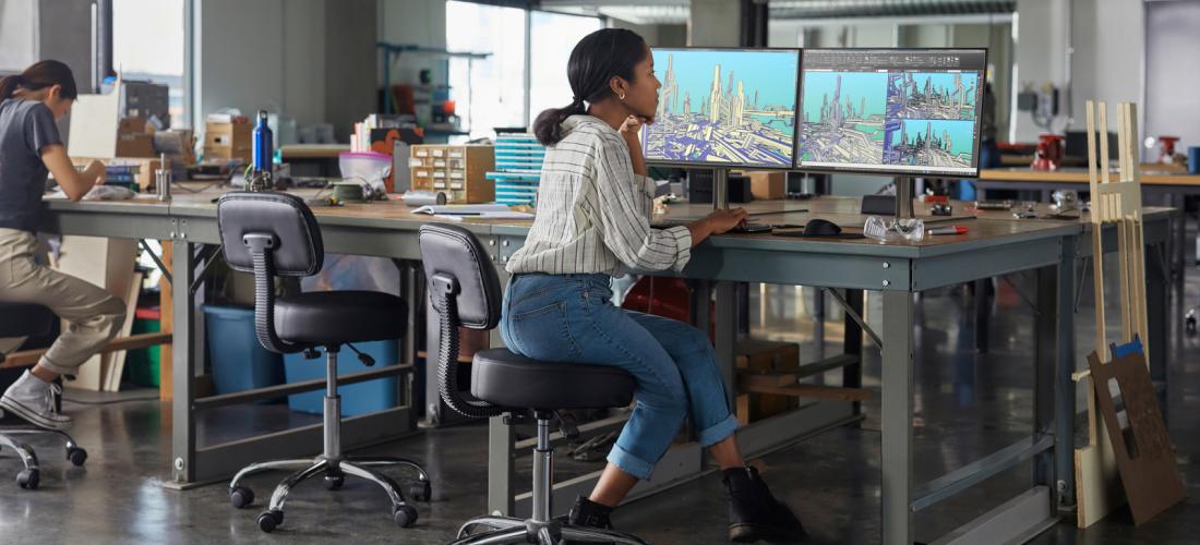 Woman at desk with multiple screens